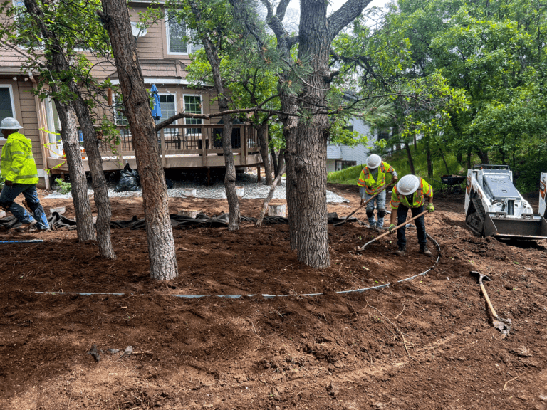 Residential construction site with workers doing landscaping