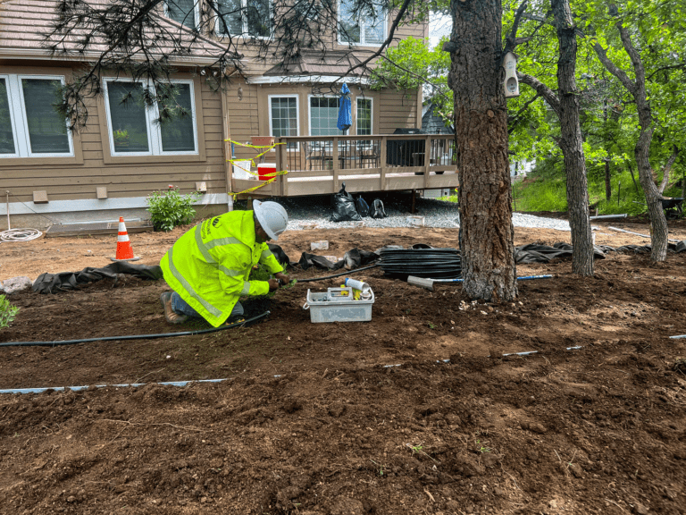 construction worker bent over tools in dirt
