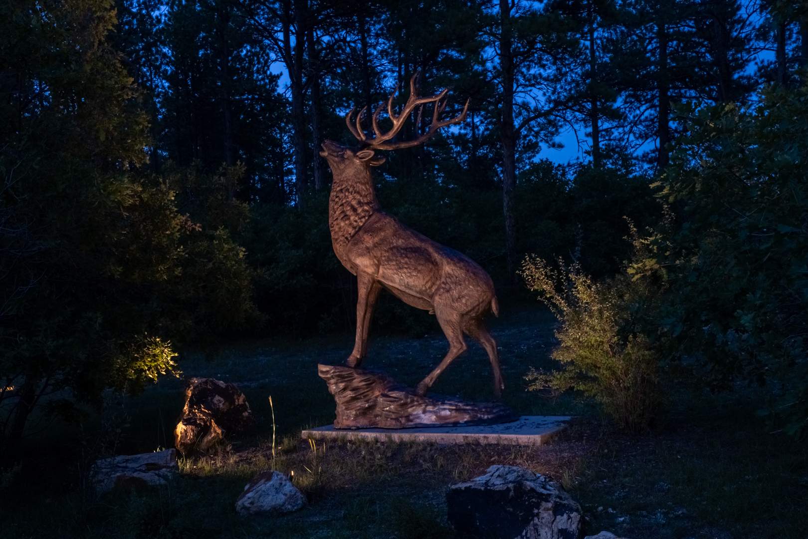 Bronze Elk Statue with cross lighting